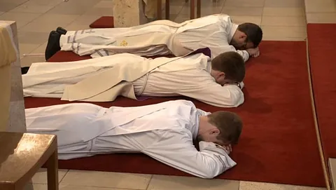 Priesterweihe in St. Matthias Schöneberg - Drei Priester liegen während der Weihezeremonie vor dem Altar